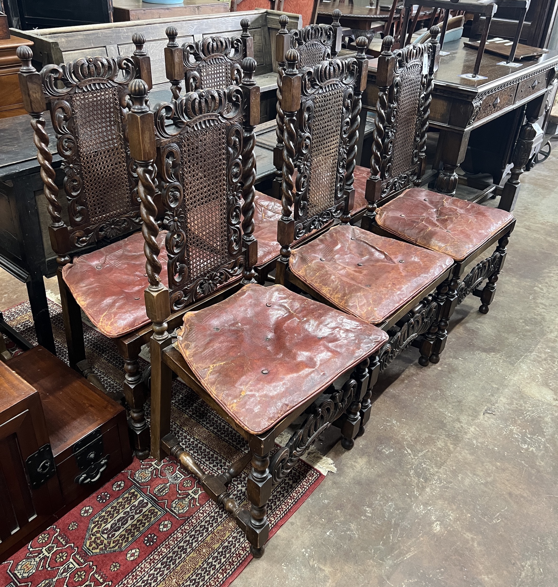 A set of six Jacobean revival carved caned beech dining chairs with leather squab seats